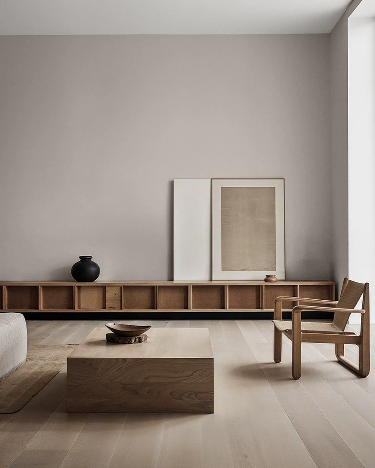 Flügger Navigli living room with neutral walls, wooden shelving and a lounge chair