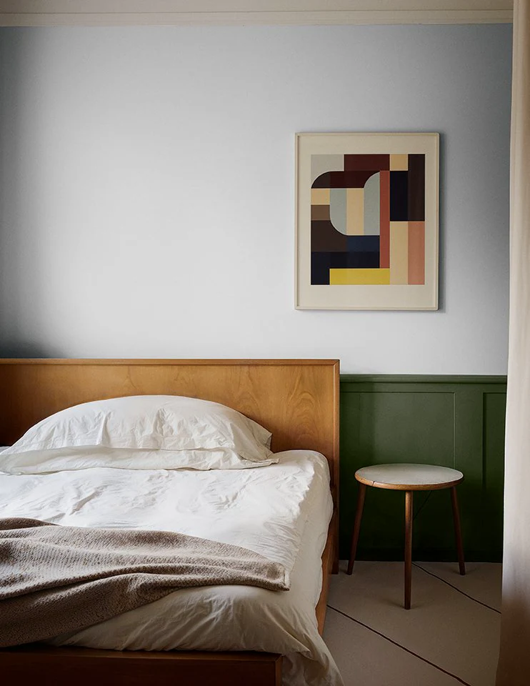 Flügger Fine Baja bedroom with green wall panelling and a wooden bed